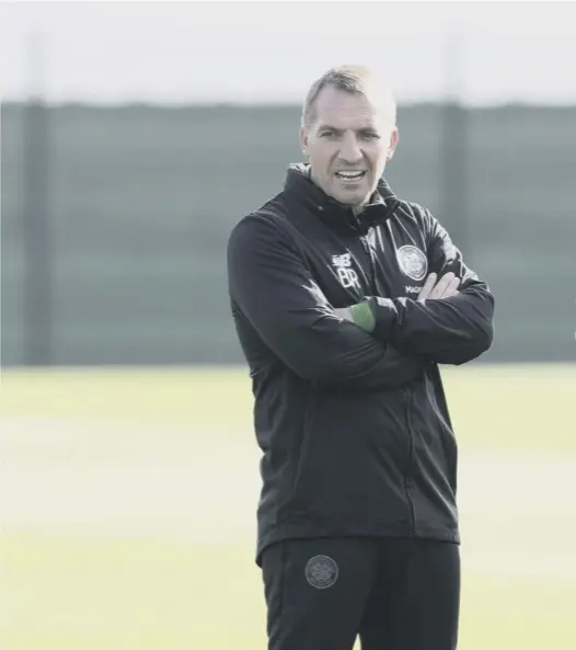  ??  ?? At a sunny Lennoxtown yesterday, Brendan Rodgers chats with striker Leigh Griffiths, who will this afternoon try to score against the