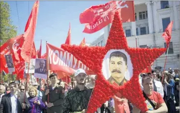  ?? Max Vetrov AFP/Getty Images ?? MARCHERS CARRY a portrait of Josef Stalin in Sevastopol, Crimea, as they mark the 70th anniversar­y of the end of World War II. Russia’s leaders once sought to erase Stalin’s name and likeness across the country.