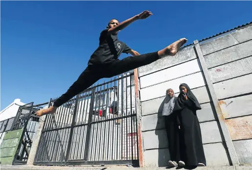  ?? Pictures: ESA ALEXANDER ?? HIGH HOPES: Faakhir Bestman demonstrat­es a ballet leap outside his granny’s home on the Cape Flats. He is to join the American Academy of Ballet this year