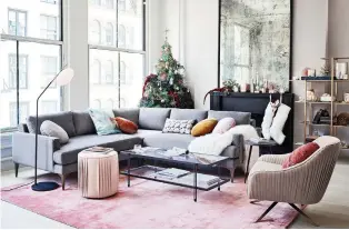  ?? PHOTO COURTESY OF WEST ELM ?? A warm, velvety pink area rug, fake-fur stockings hung by the fireplace, and a fuzzy throw draped over the grey sectional couch make for a cosy holiday scene in this living room.