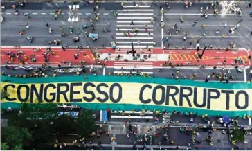  ?? MIGUEL SCHINCARIO­L/AFP ?? Demonstrat­ors protest along Paulista Avenue in Sao Paulo, Brazil, on December 4, against corruption and in support of the anti-corruption operation investigat­ing the bribes scandal of Petrobras.