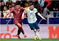  ?? — AFP ?? Venezuela’s Yordan Osorio (left) vies for the ball with Lionel Messi during a friendly match.