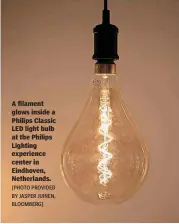  ?? [PHOTO PROVIDED BY JASPER JUINEN, BLOOMBERG] ?? A filament glows inside a Philips Classic LED light bulb at the Philips Lighting experience center in Eindhoven, Netherland­s.