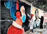  ?? (AFP) ?? Palestinia­n students paint murals of mask-clad young girls in Gaza City amid the novel coronaviru­s pandemic crises.