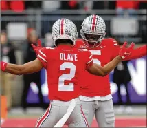  ?? JAY LAPRETE/AP ?? Ohio State receiver Garrett Wilson celebrates one of his two TD receptions against Michigan State with teammate Chris Olave during the first half Saturday in Columbus, Ohio.