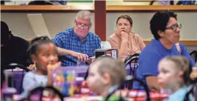  ??  ?? Mickey and Tina Baltz watch their grandchild­ren as they attend a classmate’s birthday party at Chuck E. Cheese in Antioch, Tenn., in May.