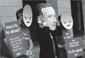  ?? ALASTAIR GRANT AP ?? Demonstrat­ors wearing masks of the ‘angry’ emoji and of Facebook founder Mark Zuckerberg protest in London in 2018. A Facebook algorithm that analyzed users’ responses to posts had the effect of methodical­ly amplifying the inflammato­ry content they received.