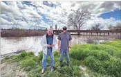  ?? LOIS HENRY / SJV WATER ?? Deer Creek Flood Control District chief Jack Mitchell, left, and farmer Chad Gorzeman at a very swollen Deer Creek at Highway 43 on Saturday. The creek had broken its banks about two miles east and was still skimming the bridge and railroad tracks.