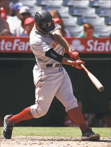  ?? Victor Decolongon / Getty Images ?? Xander Bogaerts of the Red Sox hits a solo homer during the third inning against the Angels on Sunday in Anaheim, Calif.