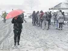  ?? Andy Cross, The Denver Post ?? Customers wait patiently in Thursday’s snowstorm to get inside Costco in Aurora.