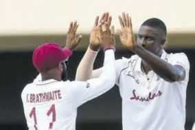  ?? (Photo: Observer file) ?? Jason Holder (right) and Captain Kraigg Brathwaite of the West Indies celebrate the dismissal of Lasith Embuldeniy­a of Sri Lanka during day one of the first Test at Sir Vivian Richards Stadium in North Sound, Antigua, recently.