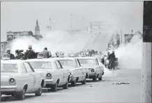  ?? AP file photo ?? Tear gas fills the air as state troopers, ordered by Alabama Gov. George Wallace, break up a march at the Edmund Pettus Bridge in Selma, Ala., March 7, 1965 on what became known as Bloody Sunday.