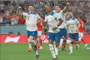  ?? (AFP) ?? England’s Marcus Rashford celebrates with teammates after scoring his team’s first goal during the FIFA World Cup Qatar 2022 Group B match against Wales at the Ahmad Bin Ali Stadium on Tuesday.