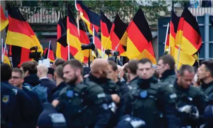  ??  ?? Supporters of the AfD party wave German flags as they walk behind police during a demonstrat­ion in Chemnitz, Germany, October 2020. Photograph: John MacDougall/AFP/Getty Images