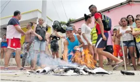  ?? JOHN ROBLEDO ?? Habitantes de Carrizal queman los recibos que le fueron retirados al funcionari­o.