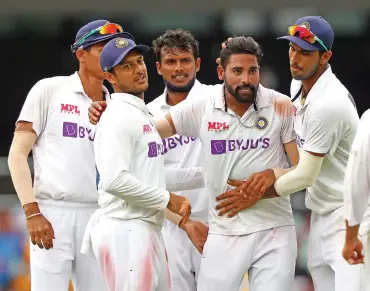  ?? (AFP) ?? India's Mohammed Siraj (second from right) celebrates with teammates after picking a wicket on day four of the fourth Test against Australia on Monday