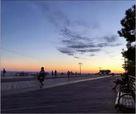  ?? AP PHOTO COLLEEN NEWVINE ?? This 2019 image shows the Coney Island boardwalk at sunset after a 12 mile walk from the northern tip of Brooklyn, in Greenpoint, down to its southern shore on the Atlantic.