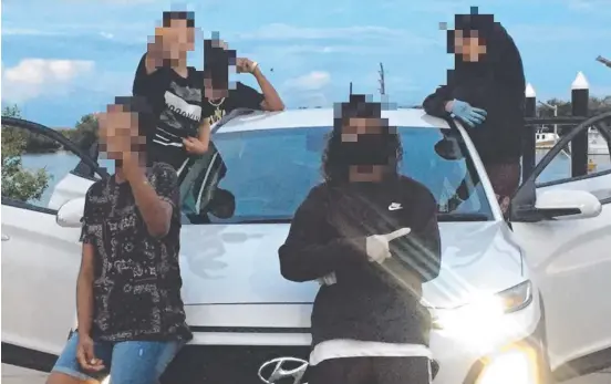  ?? ?? A group of young people pose in front of a stolen car in an image shared to the Townsville crime Instagram page.