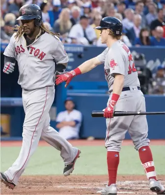  ?? AP PHOTO ?? SHIFT: Hanley Ramirez gets a hand from Brock Holt as he scores a run in the second inning of the Sox’ win last night in Toronto.