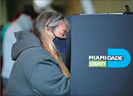  ?? REBECCA BLACKWELL/ AP PHOTO ?? A woman fills out her ballot at a polling place at Indian Creek Fire Station # 4 in Miami Beach, Fla., on Election Day.