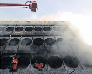  ??  ?? DEADLY BLAZE: Firefighte­rs spray water on burning buildings after a bomb attack in Sungai Kolok on Friday. Three were killed in the fire.