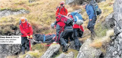  ??  ?? Easy does it Rescue team carry stricken walker to safety