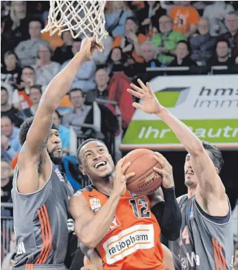  ?? FOTO: DPA ?? Kaum ein Durchkomme­n: Ulms Trey Lewis wird von Devin Booker (li.) und Nihad Djedovic beharkt.