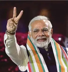  ?? EPA PIC ?? Indian Prime Minister Narendra Modi makes a victory sign in New Delhi on Dec 18, after his party, Bharatiya Janata Party (BJP), won the Gujarat assembly elections. BJP bagged 43 of 55 urban seats, but only 56 of 127 in the countrysid­e.