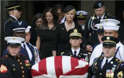  ?? SUSAN WALSH — THE ASSOCIATED PRESS ?? Cindy McCain, center, widow of Sen. John McCain, R-Ariz., escorted by Jimmy McCain and other family members, follow his casket as it is carried out of Washington National Cathedral in Washington, Saturday following a memorial service.