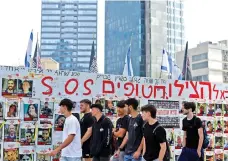  ?? ?? People walk past posters with pictures of hostages kidnapped during the deadly Oct 7 attack on Israel by Hamas, in Tel Aviv