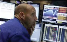  ?? THE ASSOCIATED PRESS ?? Specialist Meric Greenbaum works at his post on the floor of the New York Stock Exchange Friday. U.S. stocks opened slightly lower after a sharp two-day surge, as the stock market closes out a wild week.