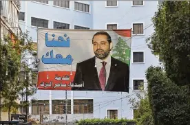  ?? BILAL HUSSEIN / AP ?? A poster of outgoing Lebanese Prime Minister Saad Hariri hangs on a street in Beirut, Lebanon, on Monday. Hariri’s stunning resignatio­n — announced last weekend from Saudi Arabia in a pre-recorded message — has thrown Lebanon into turmoil, potentiall­y...