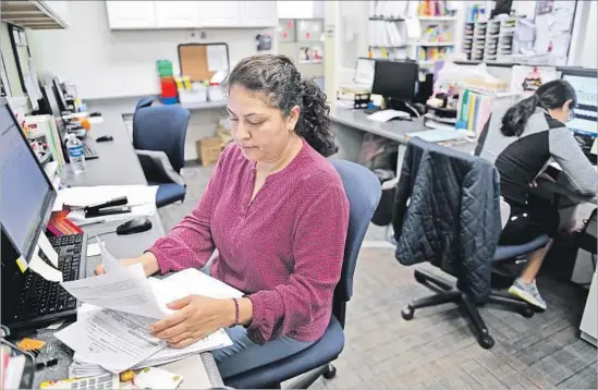  ?? Christina House For The Times ?? AZUCENA GUTIERREZ does paperwork at Pediatric Therapy Network in Torrance. High costs have left housing in that city out of reach for her and other workers.