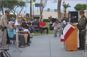  ?? JULIO MORALES PHOTO ?? A California Highway Patrol officer rings a ceremonial bell during the ninth annual Imperial Valley Law Enforcemen­t Memorial on Friday in front of the El Centro courthouse as El Centro Sector Border Patrol Assistant Chief David Kim (right) reads off...