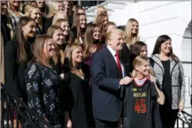  ?? EVAN VUCCI — THE ASSOCIATED PRESS ?? President Donald Trump poses for photograph­s with the University of Maryland women’s lacrosse team during an event with NCAA championsh­ip teams at the White House, Friday in Washington.