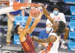  ?? MICHAEL CONROY/ASSOCIATED PRESS ?? Florida forward Anthony Duruji, right, dunks the ball as Virginia Tech forward Keve Aluma is late in trying to stop him in overtime of a first-round NCAA tournament game Friday at Hinkle Fieldhouse in Indianapol­is.