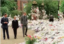  ??  ?? Prince Charles, Prince William and Prince Harry look at some of the tributes left for Diana, Princess of Wales.