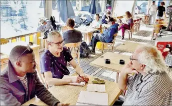  ?? - Crédits : CLA ?? Serge Tartas, patron du de la brasserie «Le progrès», en discussion avec Essoyoméné Kamana, manager de ville et Olivier Duhamel animateur de ville.