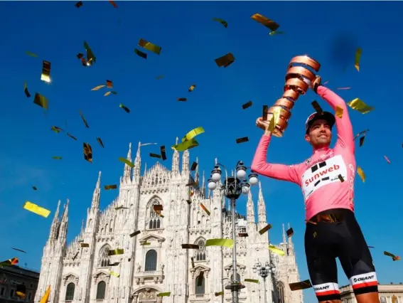  ??  ?? Tom Douholds lifts the trophy in the shadow of Milan’s famous cathedral (Getty)