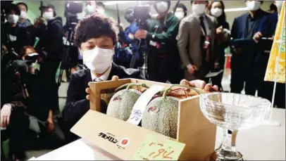  ?? AFP ?? A man shows a pair of the famed Yubari Melons during the season’s first auction at Sapporo Central Wholesale Market in Sapporo City on May 24.