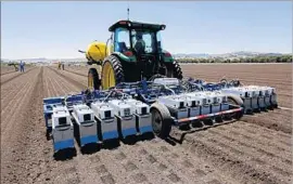  ??  ?? A LETTUCEBOT, from Blue River Technology, uses cameras, processors, computer algorithms and sprayers to precisely thin a lettuce field in Gilroy, Calif.