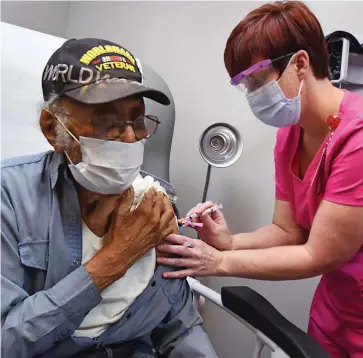  ??  ?? Veterans Affairs nurse Shasta Dockery gives World War II veteran Reuben Camp a covid-19 vaccinatio­n at the Central Arkansas Veterans Healthcare System’s Pine Bluff clinic. (Special to The Commercial/Jeff Bowen)