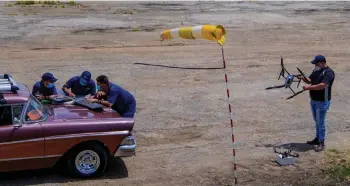  ??  ?? Members of Alasolucio­nes prepare drones for test flights at an abandoned airport in San Nicolas de Bari, Mayabeque province, Cuba.