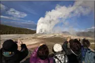  ?? JULIE JACOBSON—ASSOCIATED PRESS ?? In this May 21, 2011 file photo, tourists photograph Old Faithful erupting on schedule late in the afternoon in Yellowston­e National Park, Wyo. On Tuesday, March 24, 2020 the National Park Service announced that Yellowston­e and Grand Teton National Parks would be closed until further notice, and no visitor access will be permitted to either park..