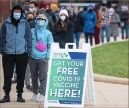  ?? Jim Watson/AFP via Getty Images ?? People wait in line at a vaccinatio­n site in Washington, D.C., on Monday. President Joe Biden told Americans not to “panic” over the newly identified COVID variant omicron and said he does not foresee new lockdowns or extending travel restrictio­ns for now.