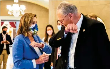  ??  ?? House Speaker Nancy Pelosi gives Senate Minority Leader Chuck Schumer of N.Y., an elbow bump as Schumer leaves following a meeting at the Capitol with White House chief of staff Mark Meadows and Treasury Secretary Steven Mnuchin on a COVID-19 relief bill on Saturday. (Photo by Manuel Balce Ceneta, AP)