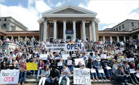  ?? PICTURE: LEON LESTRADE ?? Hundreds of UCT students and staff hold aloft banners declaring the doors of learning should be kept open, as they participat­e in a silent protest on the steps of Jameson Hall yesterday.