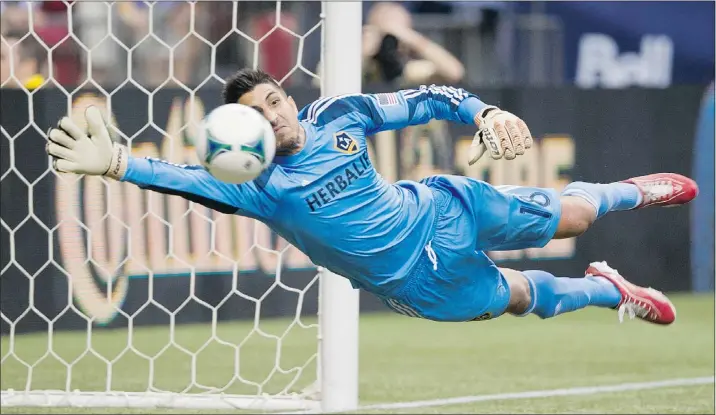  ?? GERRY KAHRMANN/PNG ?? L.A. Galaxy goalkeeper Jaime Penedo dives to make a save on a shot by Vancouver’s Jordan Harvey late in the second half of Saturday’s game at B.C. Place.