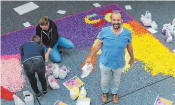  ?? FOTO: MELINA MAIER ?? Walter Rogger legt zusammen mit Juks-Schülern ein Mosaik aus 219 144 Papierküge­lchen in der Kreisspark­asse.