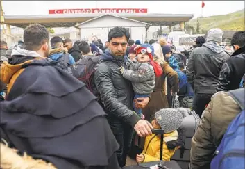  ?? Unal Cam Associated Press ?? SYRIANS wait to cross into their homeland at the border gate near the Turkish town of Antakya on Tuesday. About 20,000 Syrians living in Turkey have returned to Syria after the quakes, Turkey’s defense minister said.